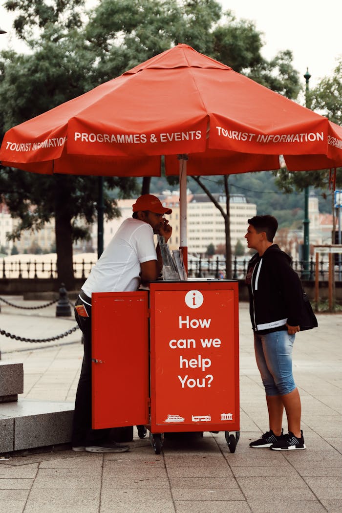 Street scene with a red tourist information booth in Budapest, Hungary.