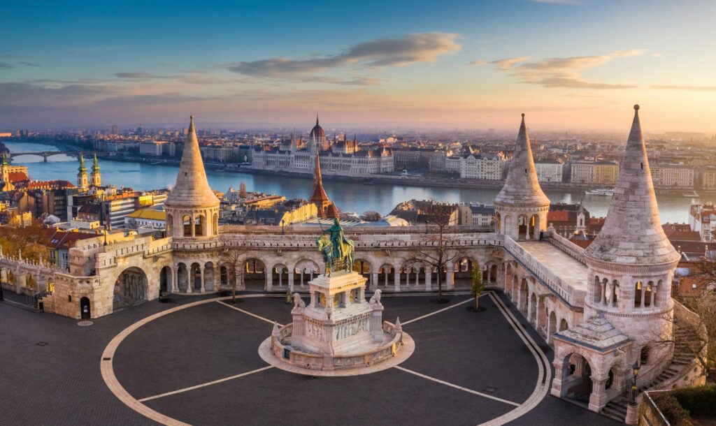 budapest, hungary the famous fisherman's bastion at sunrise with statue of king stephen i and parliament of hungary at background