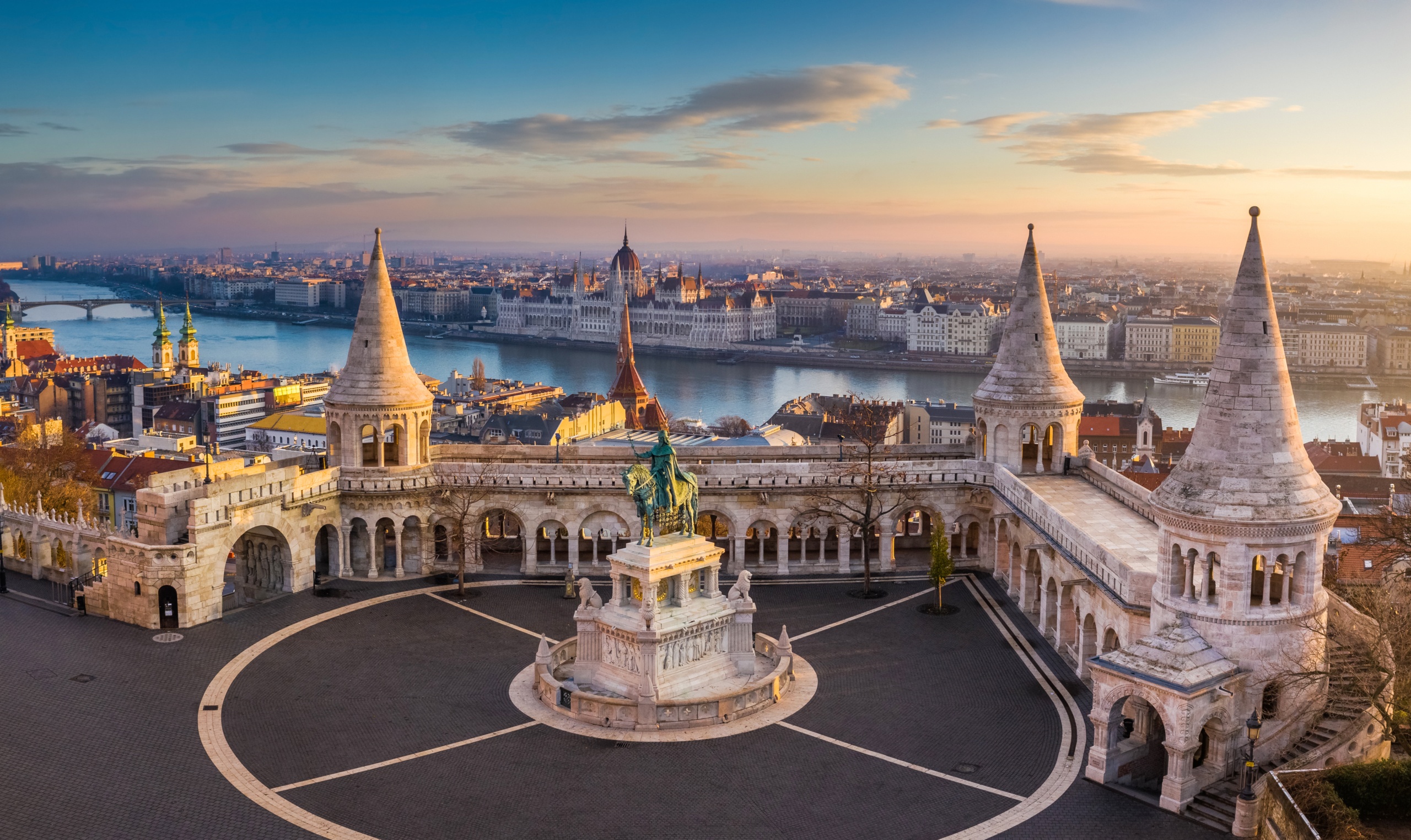 budapest, hungary the famous fisherman's bastion at sunrise with statue of king stephen i and parliament of hungary at background